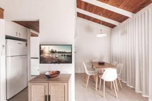 a kitchen and dining room with a table and a refrigerator at Pippi Beach Apartment in Yamba