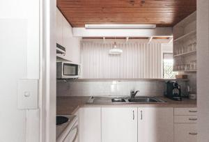 a kitchen with a sink and a microwave at Pippi Beach Apartment in Yamba