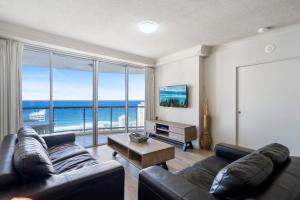 een woonkamer met een bank en een groot raam bij Chevron Renaissance - Private Apartments in Gold Coast