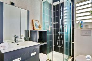La salle de bains est pourvue d'un lavabo et d'une douche en verre. dans l'établissement T2 - Les Veloutiers - La Saline-les-Bains, à La Saline les Bains