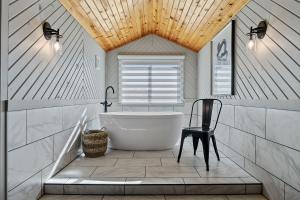 a bathroom with a white tub and a chair at Black Forest Inn Bed & Breakfast in Rapid City