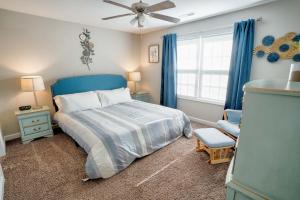 um quarto com uma cama azul e uma cadeira em Kannapolis Elegant Townhouse - Pet Friendly em Kannapolis