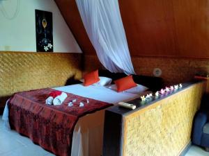 a bedroom with a bed and a table with at DEA Gili Cottages in Gili Meno