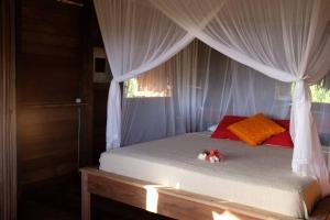 a bedroom with a bed with a canopy at Rumah Tinggi at Pachamama in Nembrala