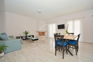 a white living room with a table and chairs at Chrysilia in Ermioni