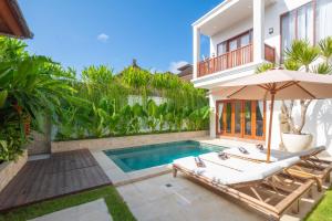 a villa with a swimming pool and a house at Puspa Ayu Villas & Apartments in Kuta