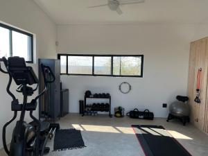 a room with a gym with a treadmill and a window at Birdsong Kruger in Marloth Park