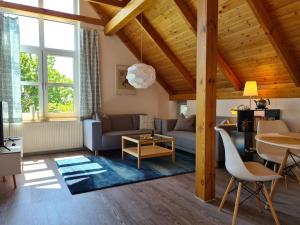 a living room with a couch and a table at Haus am Deich Ferienwohnungen in Prerow