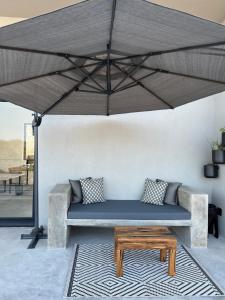un divano e un tavolo sotto un grande ombrellone di Birdsong Kruger a Marloth Park