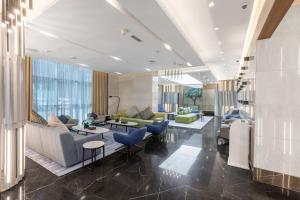 a lobby with couches and chairs and tables at City Premiere Hotel Apartments - Dubai in Dubai