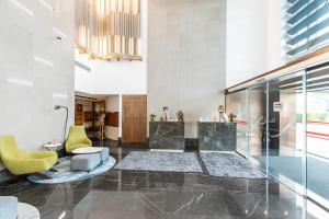 a lobby with a reception desk and a yellow chair at City Premiere Hotel Apartments - Dubai in Dubai