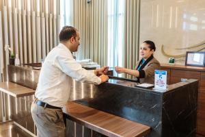 a man and a woman standing at a counter at City Premiere Hotel Apartments in Dubai