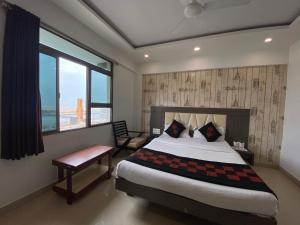 a bedroom with a large bed and a window at Hotel Gomti Dwarka in Dwarka