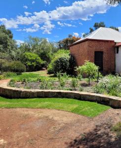 a garden in front of a brick building at Talbot - Rustic style accommodation with Mod Cons in Hoddy Well