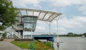 a building next to a body of water at Pension zur Regatta in Brandenburg an der Havel
