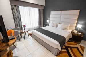 a hotel room with a large bed and a television at City Premiere Hotel Apartments - Dubai in Dubai