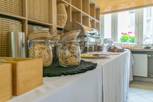 un mostrador de cocina con jarras de comida. en Hôtel Le Petit Poète, en Echternach