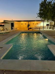 a swimming pool with a bench in the middle at Casa rural La Alcaparra in Écija