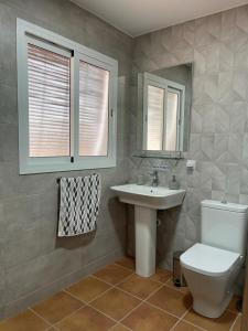 a bathroom with a toilet and a sink and mirror at Casa rural La Alcaparra in Écija