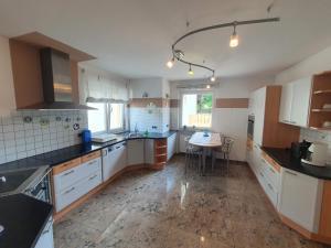 a kitchen with white cabinets and a table in it at Ferienwohnung Camping Goldrain in Coldrano