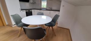 kuchnia z białym stołem i 4 krzesłami w obiekcie Ferienwohnung Camping Goldrain w mieście Coldrano