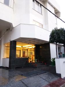 a white building with a staircase in front of it at HOTEL NEW ANAND PALACE in Alīgarh