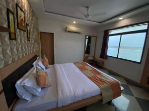 a bedroom with a bed and a window at Hotel Gomti Dwarka in Dwarka