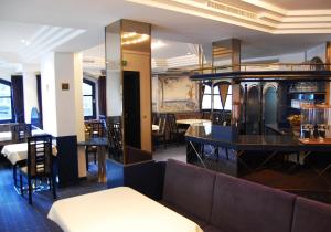 un ristorante con tavoli, sedie e un divano di Langley Hotel Rendlhof a Sankt Anton am Arlberg