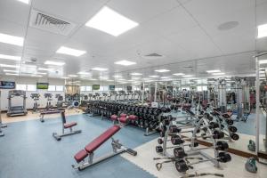 a gym with a large room filled with lots of machines at City Premiere Hotel Apartments - Dubai in Dubai