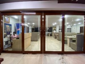 a room with glass doors and a woman sitting in a chair at Hotel Gomti Dwarka in Dwarka