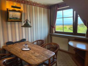 a dining room with a wooden table and chairs and a window at Moby Dick Hotel & Ferienwohnungen in Wustrow