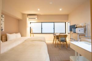 a hotel room with a large bed and a table at Ostay Ueno in Tokyo +49 photos