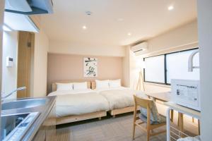 a bedroom with a large bed and a desk at Ostay Ueno in Tokyo
