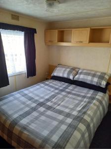 a bedroom with two beds and a window in it at Caravan on Golden Palm MV24 Chapel St Leonards in Chapel Saint Leonards