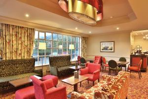 a living room with couches and tables and chairs at Reigate Manor Hotel in Reigate