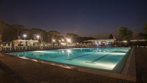 a swimming pool at night with lights at Fabulous village in Casal Palocco