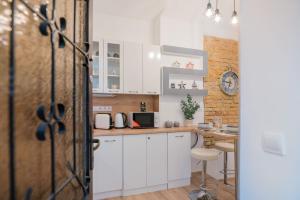 una pequeña cocina con armarios blancos y una mesa en Oktogon City Apartment, en Budapest