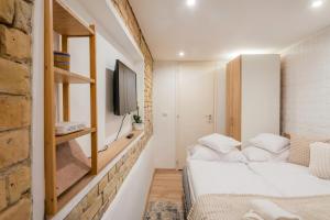 Habitación pequeña con 2 camas y TV. en Oktogon City Apartment, en Budapest