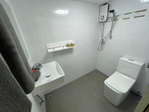 a white bathroom with a toilet and a sink at Vanara Bungalows in Ko Chang