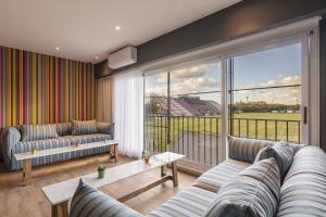 a living room with two couches and a large window at Clayton Buenos Aires in Buenos Aires