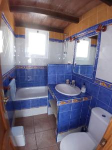 uma casa de banho azul com uma banheira, um lavatório e um WC. em CASA TORRE DEL MANZANO em Torrox Costa