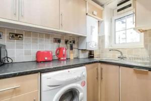 a kitchen with a washing machine on a counter at APlaceToStay Central London apartment, Zone 1 BAK in London