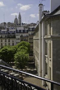 a view of a city from the balcony of a building at Le Montclair Montmartre by River in Paris