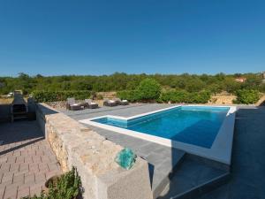 uma piscina num quintal com uma parede de pedra em Fantastic villa in Ugljane with private pool em Ugljane