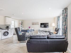 a living room with a couch and chairs and a kitchen at Hebe in Dorchester