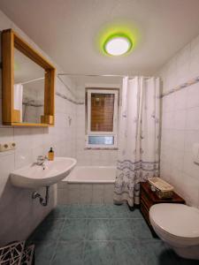 a bathroom with a sink and a tub and a toilet at Ferienwohnung Storchennest in Volkach