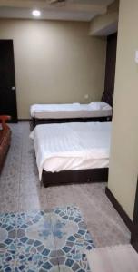 two twin beds in a room with a rug at Tabin Lodge in Lahad Datu