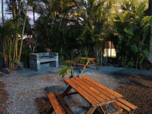 - une table de pique-nique et un banc dans un parc planté de palmiers dans l'établissement Ti Kaz Fond de Puits, à Saint-Philippe