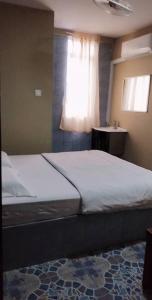 拿篤的住宿－Tabin Lodge，一间卧室设有一张大床和一个窗户。