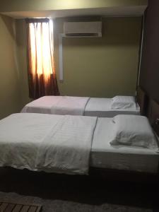 拿篤的住宿－Tabin Lodge，卧室设有两张单人床和窗户。
